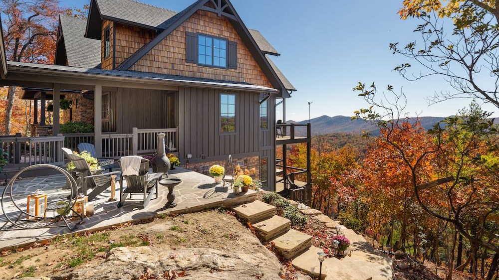 A Powell Construction custom mountain home in the Highlands area, cedar and stone construction set into mature forest with fall foliage